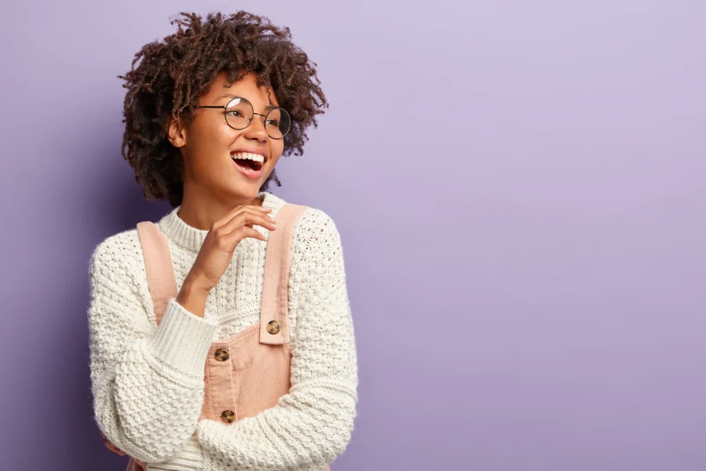 carefree-beautiful-ethnic-female-model-laughs-happily-touches-chin-gently